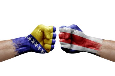 Two hands punch to each others on white background. Country flags painted fists, conflict crisis concept between bosnia and costa rica
