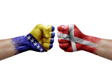 Two hands punch to each others on white background. Country flags painted fists, conflict crisis concept between bosnia and denmark