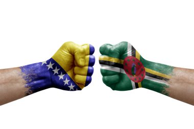 Two hands punch to each others on white background. Country flags painted fists, conflict crisis concept between bosnia and dominica