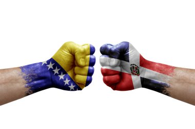 Two hands punch to each others on white background. Country flags painted fists, conflict crisis concept between bosnia and dominican republic