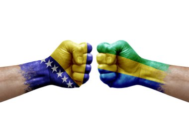 Two hands punch to each others on white background. Country flags painted fists, conflict crisis concept between bosnia and gabon