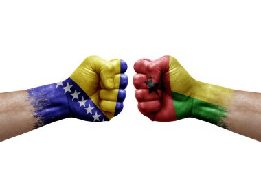 Two hands punch to each others on white background. Country flags painted fists, conflict crisis concept between bosnia and guinea-bissau