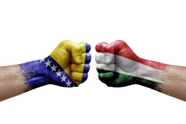 Two hands punch to each others on white background. Country flags painted fists, conflict crisis concept between bosnia and hungary