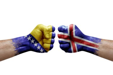 Two hands punch to each others on white background. Country flags painted fists, conflict crisis concept between bosnia and iceland