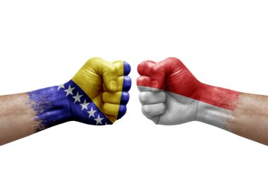 Two hands punch to each others on white background. Country flags painted fists, conflict crisis concept between bosnia and indonesia