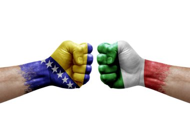 Two hands punch to each others on white background. Country flags painted fists, conflict crisis concept between bosnia and italy