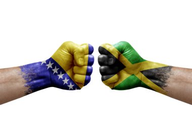 Two hands punch to each others on white background. Country flags painted fists, conflict crisis concept between bosnia and jamaica