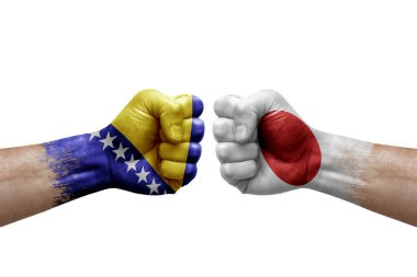 Two hands punch to each others on white background. Country flags painted fists, conflict crisis concept between bosnia and japan