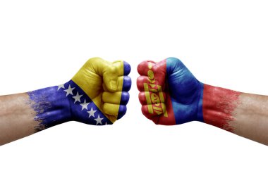 Two hands punch to each others on white background. Country flags painted fists, conflict crisis concept between bosnia and mongolia