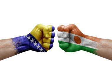Two hands punch to each others on white background. Country flags painted fists, conflict crisis concept between bosnia and niger