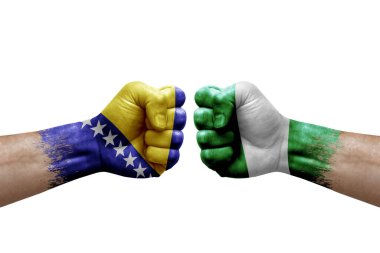 Two hands punch to each others on white background. Country flags painted fists, conflict crisis concept between bosnia and nigeria