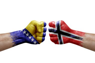 Two hands punch to each others on white background. Country flags painted fists, conflict crisis concept between bosnia and norway