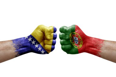 Two hands punch to each others on white background. Country flags painted fists, conflict crisis concept between bosnia and portugal