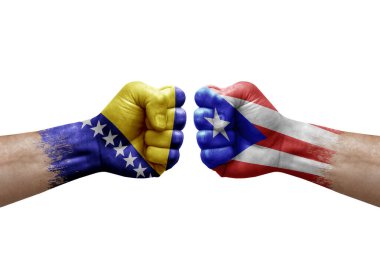 Two hands punch to each others on white background. Country flags painted fists, conflict crisis concept between bosnia and puerto rico