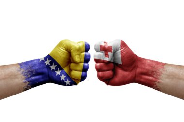 Two hands punch to each others on white background. Country flags painted fists, conflict crisis concept between bosnia and tonga