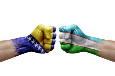 Two hands punch to each others on white background. Country flags painted fists, conflict crisis concept between bosnia and uzbekistan