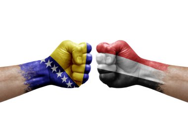 Two hands punch to each others on white background. Country flags painted fists, conflict crisis concept between bosnia and yemen