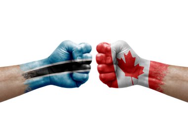 Two hands punch to each others on white background. Country flags painted fists, conflict crisis concept between botswana and canada