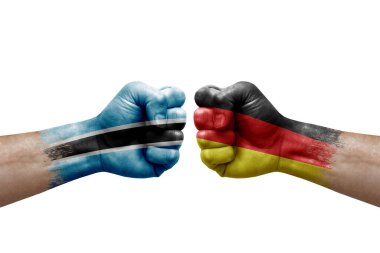Two hands punch to each others on white background. Country flags painted fists, conflict crisis concept between botswana and germany