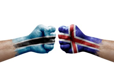 Two hands punch to each others on white background. Country flags painted fists, conflict crisis concept between botswana and iceland
