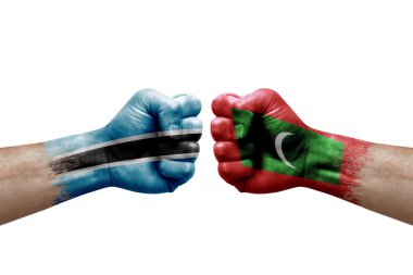 Two hands punch to each others on white background. Country flags painted fists, conflict crisis concept between botswana and maldives