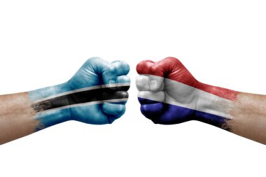 Two hands punch to each others on white background. Country flags painted fists, conflict crisis concept between botswana and netherlands
