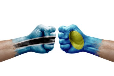 Two hands punch to each others on white background. Country flags painted fists, conflict crisis concept between botswana and palau