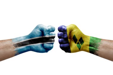 Two hands punch to each others on white background. Country flags painted fists, conflict crisis concept between botswana and saint vincent and the grenadines