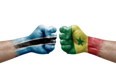 Two hands punch to each others on white background. Country flags painted fists, conflict crisis concept between botswana and senegal