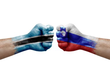 Two hands punch to each others on white background. Country flags painted fists, conflict crisis concept between botswana and slovenia
