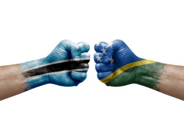Two hands punch to each others on white background. Country flags painted fists, conflict crisis concept between botswana and solomon islands