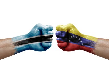 Two hands punch to each others on white background. Country flags painted fists, conflict crisis concept between botswana and venezuela