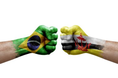 Two hands punch to each others on white background. Country flags painted fists, conflict crisis concept between brazil and brunei