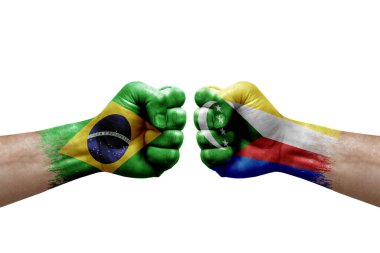 Two hands punch to each others on white background. Country flags painted fists, conflict crisis concept between brazil and comoros