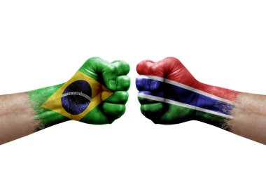 Two hands punch to each others on white background. Country flags painted fists, conflict crisis concept between brazil and gambia