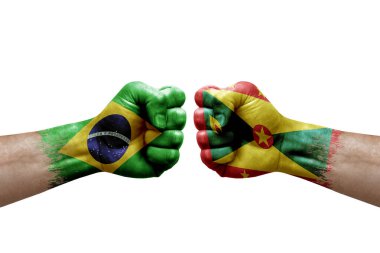 Two hands punch to each others on white background. Country flags painted fists, conflict crisis concept between brazil and grenada