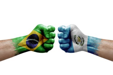 Two hands punch to each others on white background. Country flags painted fists, conflict crisis concept between brazil and guatemala