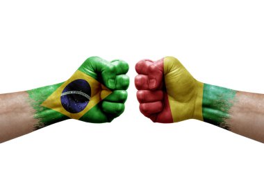 Two hands punch to each others on white background. Country flags painted fists, conflict crisis concept between brazil and guinea