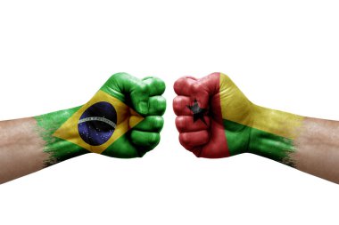 Two hands punch to each others on white background. Country flags painted fists, conflict crisis concept between brazil and guinea-bissau