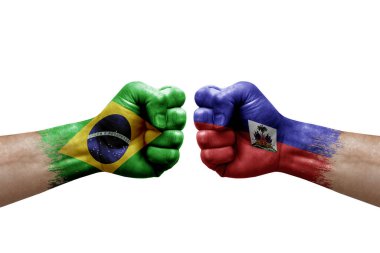 Two hands punch to each others on white background. Country flags painted fists, conflict crisis concept between brazil and haiti