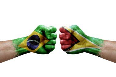 Two hands punch to each others on white background. Country flags painted fists, conflict crisis concept between brazil and guyana