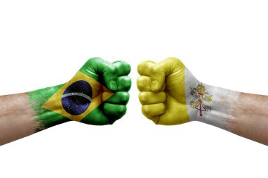 Two hands punch to each others on white background. Country flags painted fists, conflict crisis concept between brazil and holy see
