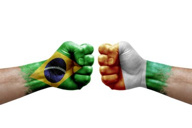 Two hands punch to each others on white background. Country flags painted fists, conflict crisis concept between brazil and ivory coast