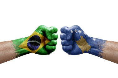 Two hands punch to each others on white background. Country flags painted fists, conflict crisis concept between brazil and kosovo
