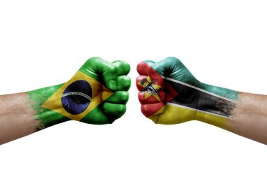 Two hands punch to each others on white background. Country flags painted fists, conflict crisis concept between brazil and mozambique