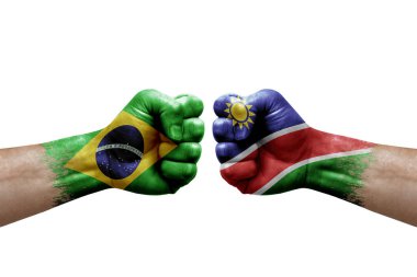 Two hands punch to each others on white background. Country flags painted fists, conflict crisis concept between brazil and namibia