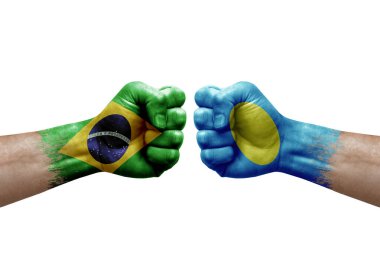 Two hands punch to each others on white background. Country flags painted fists, conflict crisis concept between brazil and palau