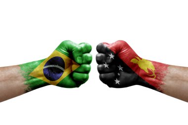 Two hands punch to each others on white background. Country flags painted fists, conflict crisis concept between brazil and papua new guinea