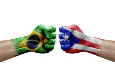 Two hands punch to each others on white background. Country flags painted fists, conflict crisis concept between brazil and puerto rico