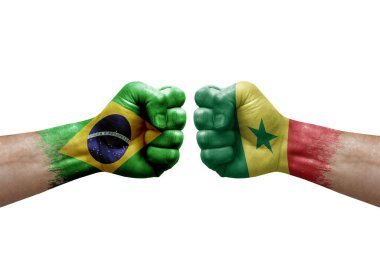 Two hands punch to each others on white background. Country flags painted fists, conflict crisis concept between brazil and senegal